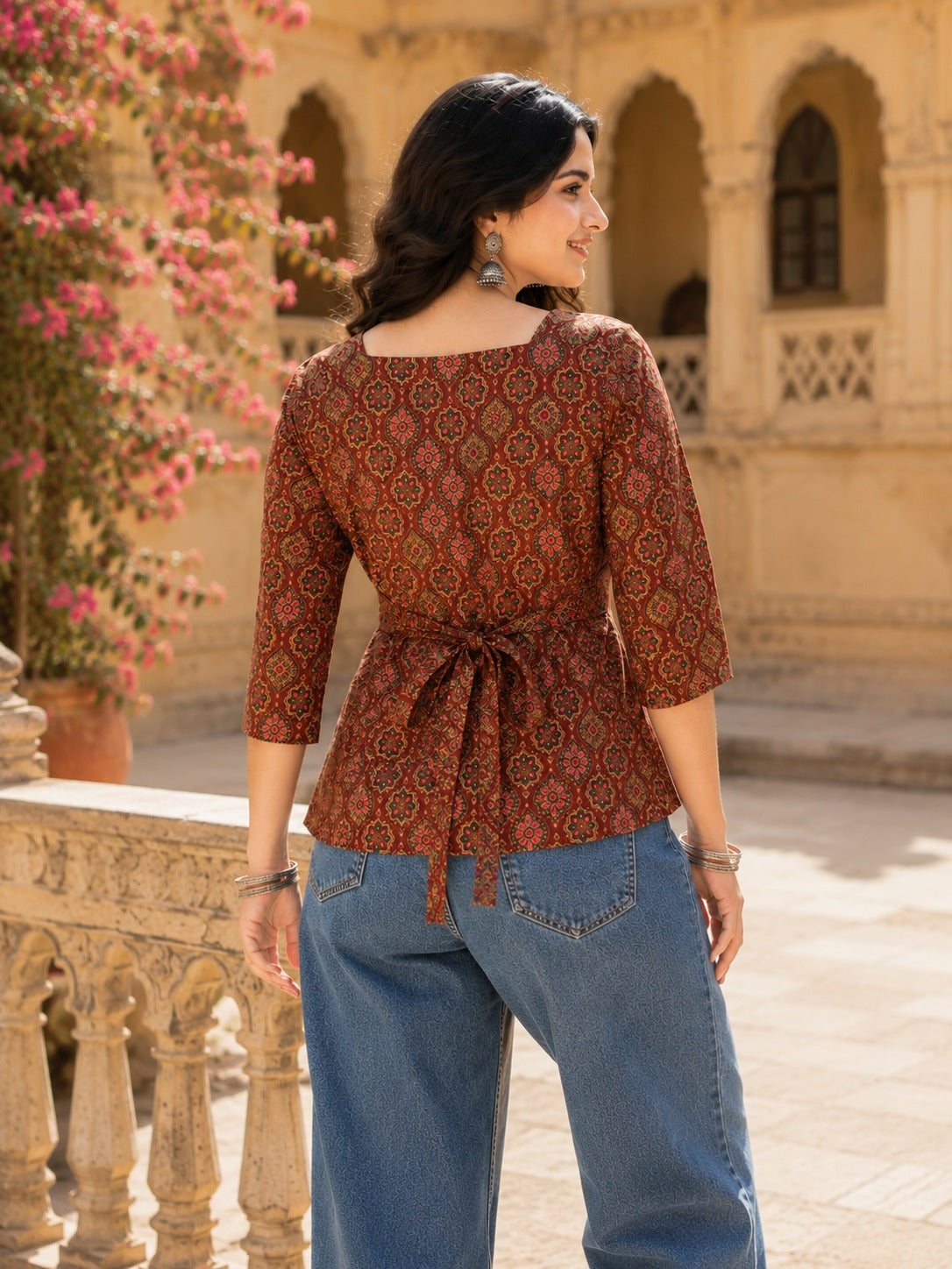 Back view of maroon Ajrakh printed fitted top for women showing tie-back waist detail with blue jeans