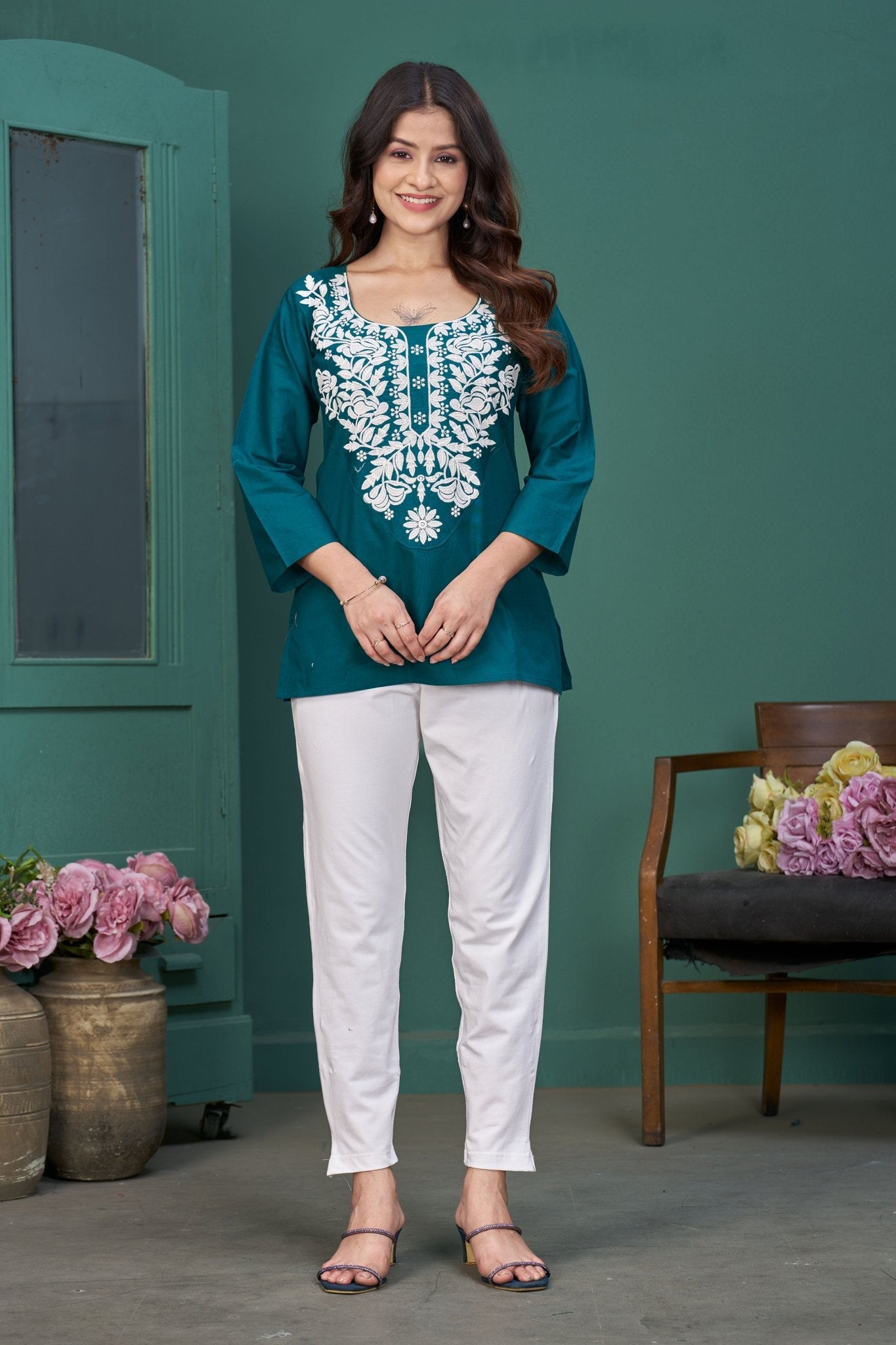 Women's teal embroidered top, front view